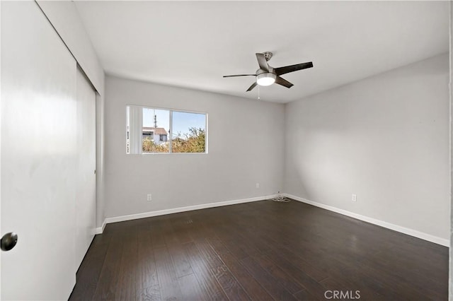 spare room featuring dark wood-type flooring and ceiling fan