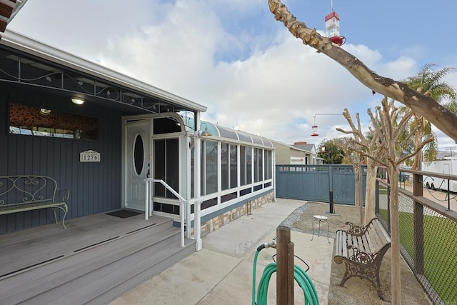 view of patio / terrace with fence and a sunroom