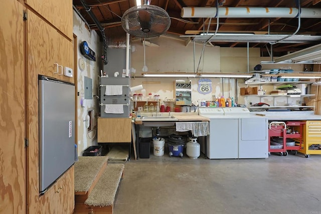 garage with a sink, a workshop area, and independent washer and dryer