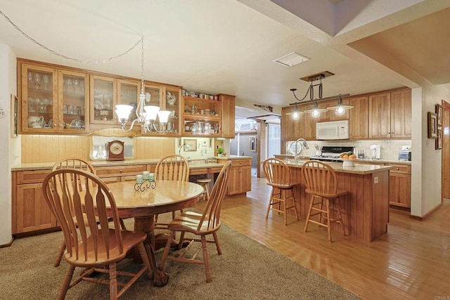 dining space featuring light wood-type flooring and a notable chandelier