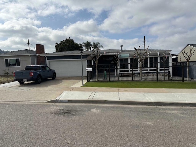 view of front of home featuring a garage, driveway, and fence