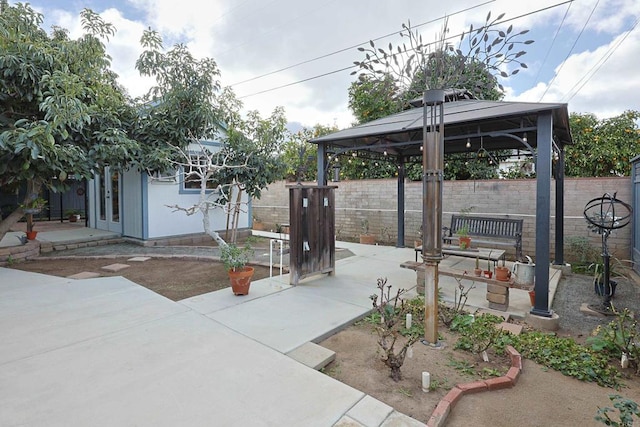 view of patio featuring fence, an outbuilding, and a gazebo