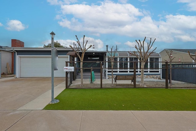 view of front facade featuring driveway, a front lawn, and fence