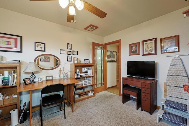 office space with a ceiling fan, light colored carpet, and visible vents