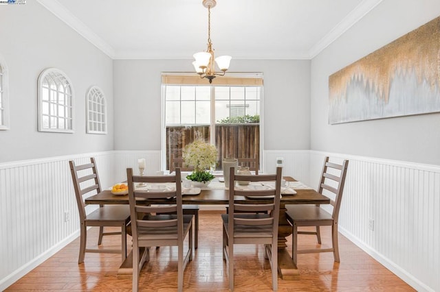 dining space with an inviting chandelier, hardwood / wood-style floors, crown molding, and a wealth of natural light