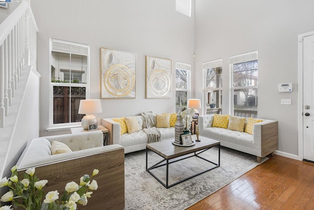 living room with wood-type flooring and a high ceiling