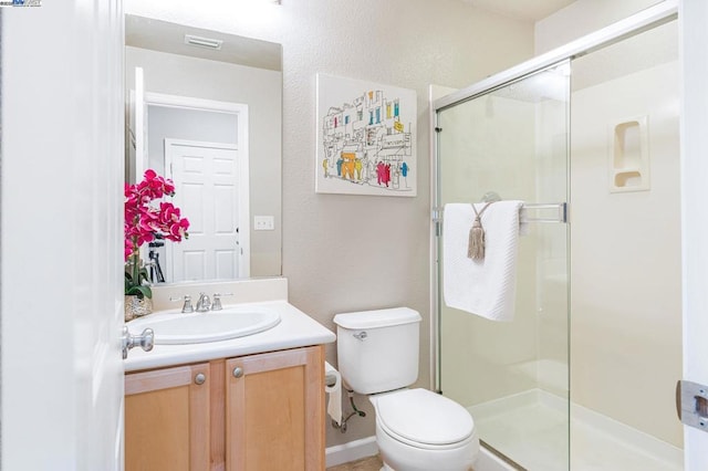 bathroom with vanity, a shower with shower door, and toilet