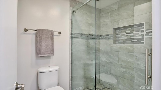 bathroom featuring toilet and an enclosed shower