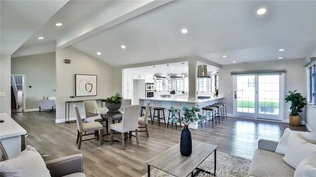 living room with hardwood / wood-style flooring and vaulted ceiling with beams