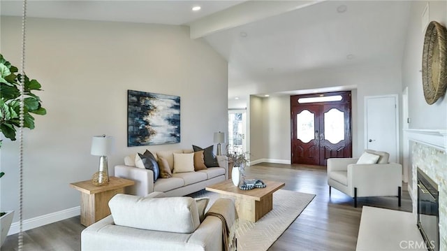 living room featuring a tile fireplace, dark hardwood / wood-style flooring, high vaulted ceiling, and beam ceiling