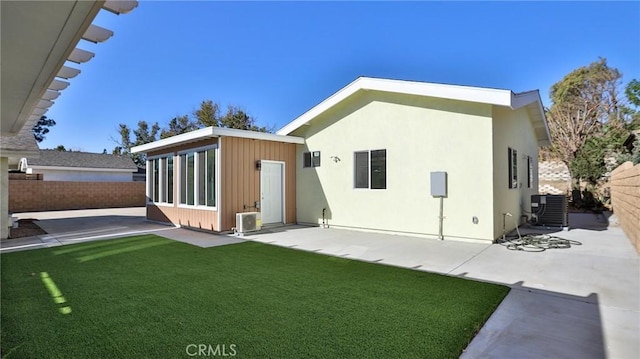 rear view of property with cooling unit, a yard, a patio area, and ac unit