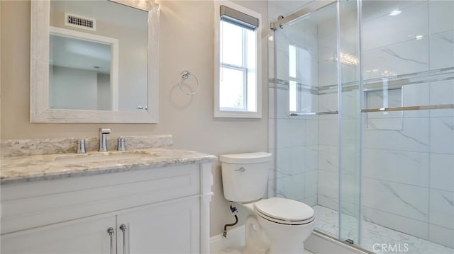 bathroom with a shower with door, vanity, and toilet