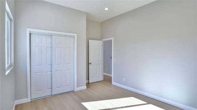 unfurnished bedroom featuring light hardwood / wood-style floors and a closet