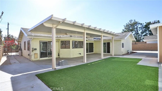 back of property with a patio area and a lawn