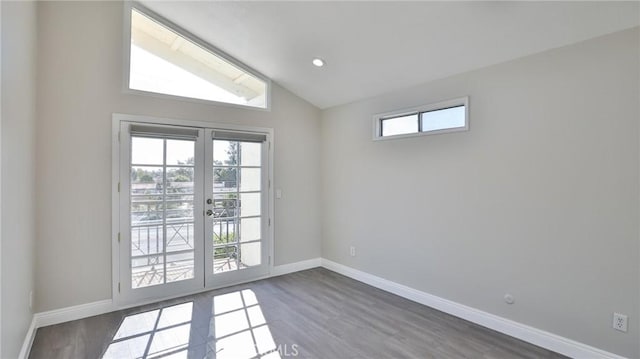 doorway with lofted ceiling, dark hardwood / wood-style floors, and french doors