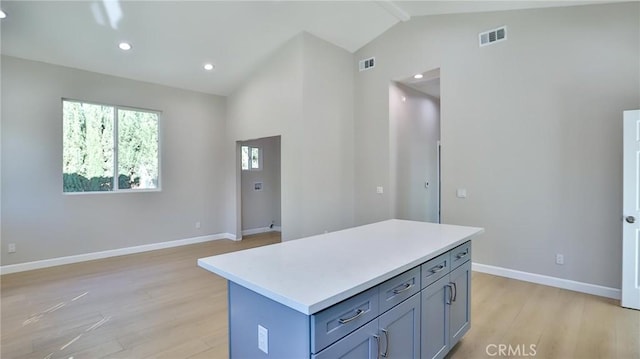 kitchen with a center island, vaulted ceiling, and light wood-type flooring