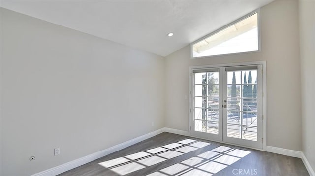 unfurnished room with lofted ceiling, dark wood-type flooring, and french doors