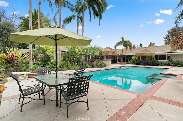 view of swimming pool featuring an in ground hot tub and a patio