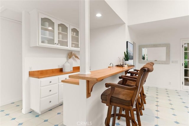 bar featuring white cabinetry and butcher block counters