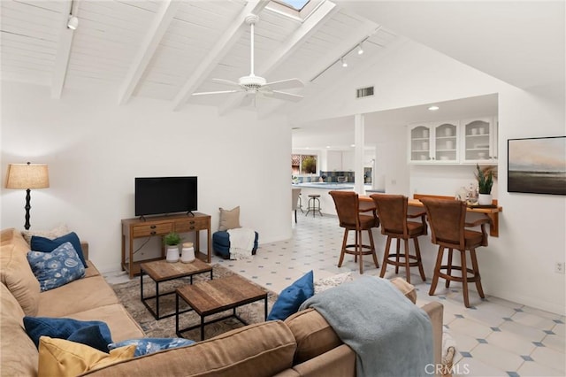 living room with ceiling fan, track lighting, vaulted ceiling with skylight, and wooden ceiling