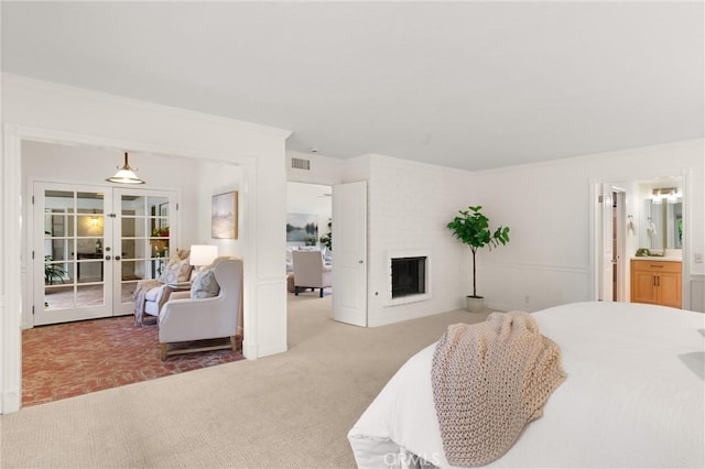 carpeted bedroom with french doors and a brick fireplace