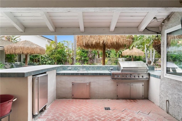 view of patio featuring a grill, sink, and an outdoor kitchen