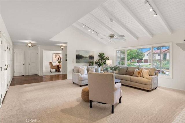 living room with light carpet, track lighting, and beamed ceiling