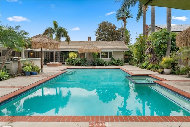 view of pool with a patio and an in ground hot tub