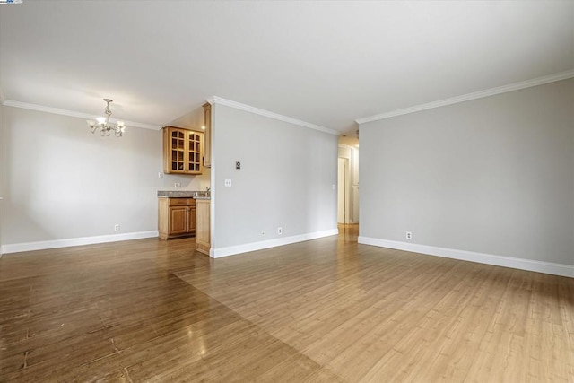 unfurnished living room featuring crown molding, light hardwood / wood-style flooring, and a chandelier