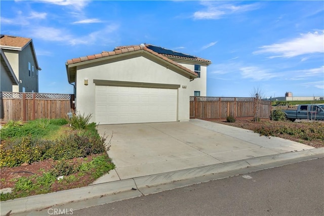 view of front facade featuring a garage and solar panels