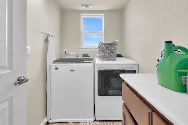 laundry room with cabinets and washing machine and clothes dryer