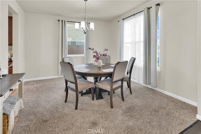 carpeted dining area with an inviting chandelier