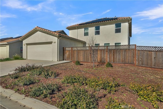 view of front of home featuring a garage and solar panels