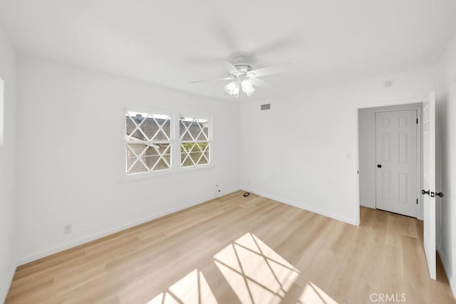 spare room with ceiling fan and light wood-type flooring