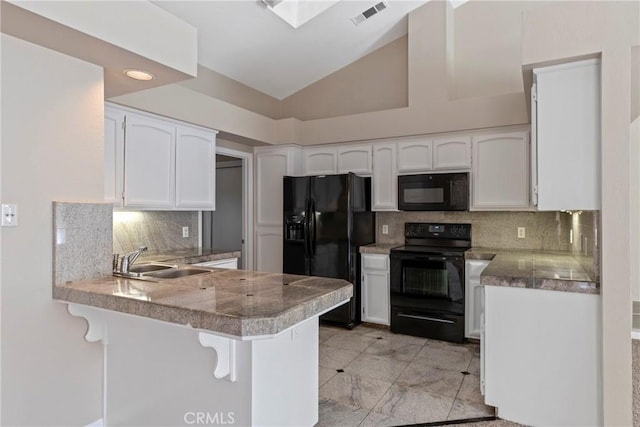 kitchen featuring sink, black appliances, kitchen peninsula, and a kitchen bar