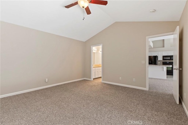 unfurnished bedroom featuring ensuite bath, ceiling fan, black refrigerator, light carpet, and vaulted ceiling