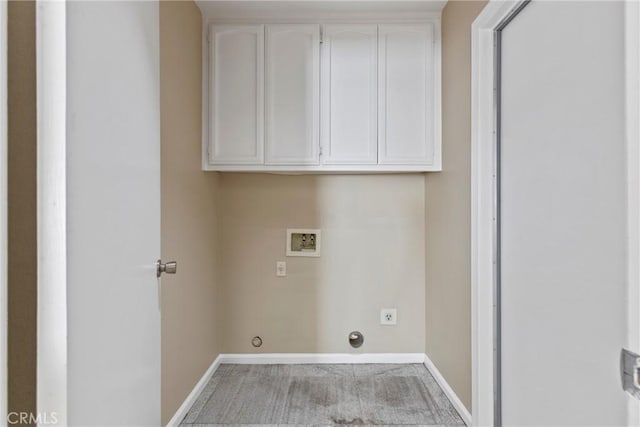 clothes washing area with washer hookup and cabinets