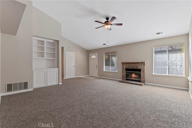 unfurnished living room featuring lofted ceiling, a brick fireplace, carpet floors, and ceiling fan