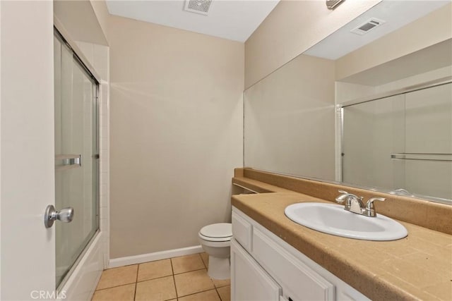 full bathroom with enclosed tub / shower combo, vanity, tile patterned floors, and toilet