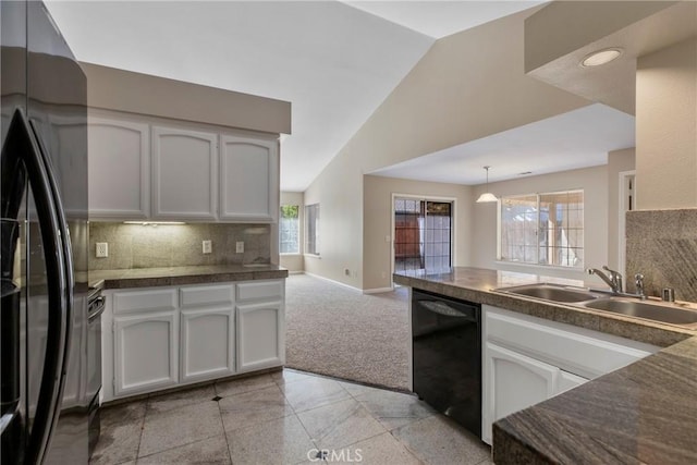 kitchen with lofted ceiling, sink, white cabinetry, black appliances, and decorative backsplash