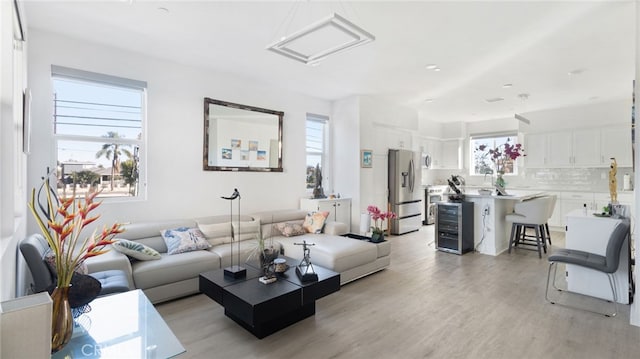 living room with beverage cooler and light hardwood / wood-style floors