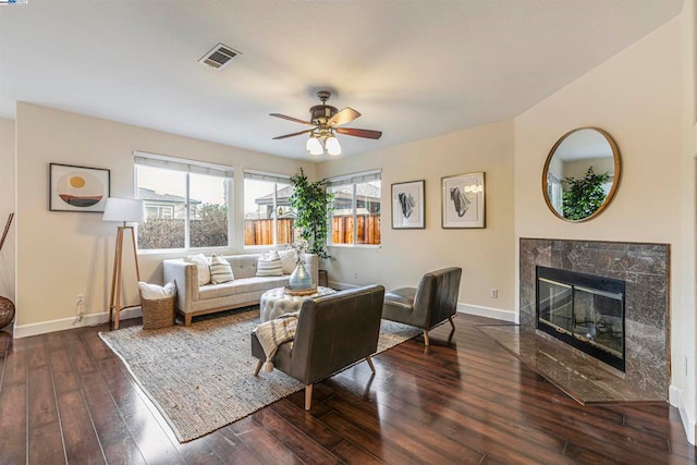 living room featuring a premium fireplace, dark hardwood / wood-style floors, and ceiling fan