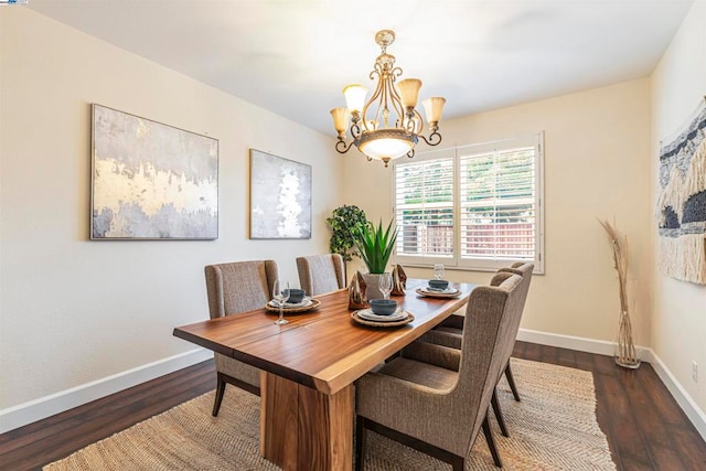 dining area with dark hardwood / wood-style flooring and a chandelier