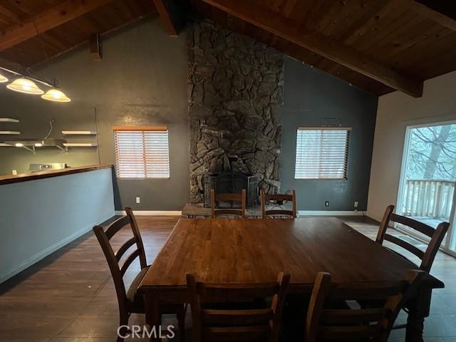 dining space featuring wood ceiling, vaulted ceiling with beams, wood finished floors, and baseboards