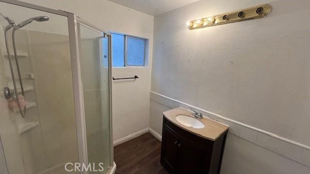 full bath with wood finished floors, a shower stall, and vanity