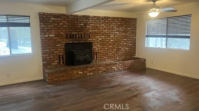 unfurnished living room featuring baseboards, a ceiling fan, wood finished floors, and a healthy amount of sunlight