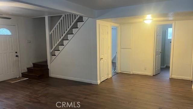 foyer entrance featuring baseboards, wood finished floors, and stairs