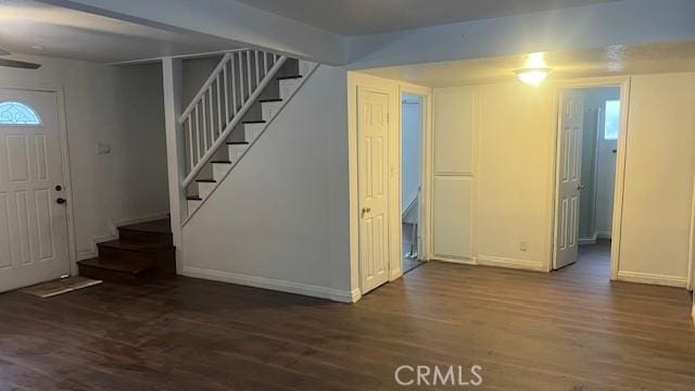 foyer entrance with baseboards, wood finished floors, and stairs