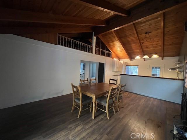 dining room featuring wood finished floors, lofted ceiling with beams, and wooden ceiling