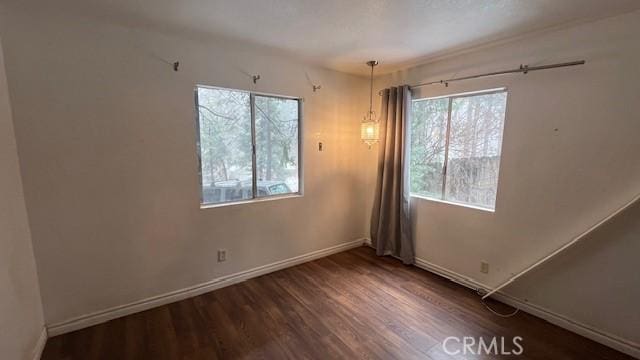 unfurnished room featuring baseboards and wood finished floors